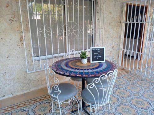 a table with two chairs and a table with a plant on it at Habitaciones independientes con baño privado #6 in Cartagena de Indias