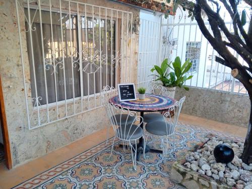 a table with chairs and a laptop on it in a patio at Habitaciones independientes con baño privado #6 in Cartagena de Indias