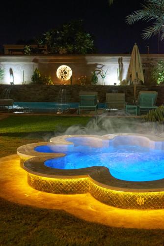 a pool of water at night with a fountain at Villa Taj Sofia & Spa in Marrakech