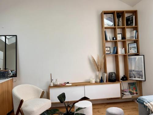 - un salon avec une étagère et des chaises dans l'établissement Magnifique T2 calme, à La Baule