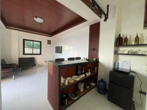 a living room with a kitchen with a shelf of wine bottles at Kamalig Beach Front in Boyog
