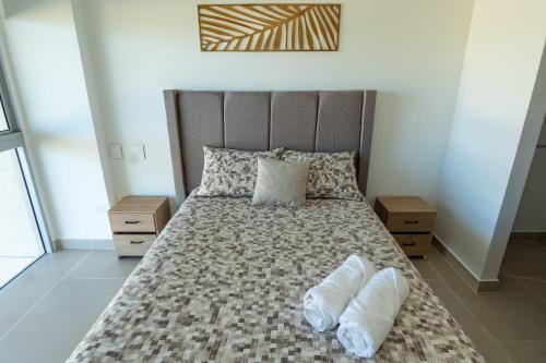 a bedroom with a bed with two white towels on it at BAIA Kristal Cartagena Condo in Cartagena de Indias