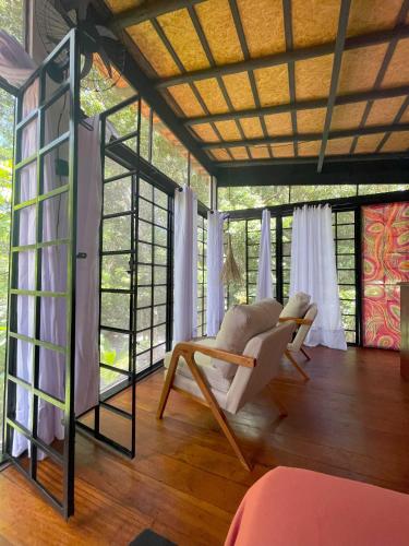 a room with two chairs and a room with windows at REFUGIO DO SAGRADO MORERE in Moreré