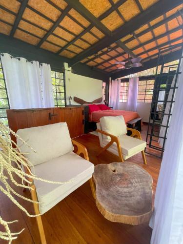 a living room with two chairs and a table at REFUGIO DO SAGRADO MORERE in Moreré