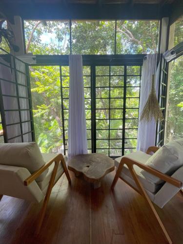 a living room with two chairs and a table in front of a window at REFUGIO DO SAGRADO MORERE in Moreré