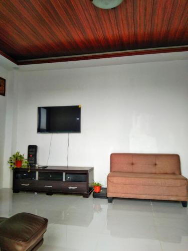 a living room with a couch and a flat screen tv at Kamalig Beach Front in Boyog
