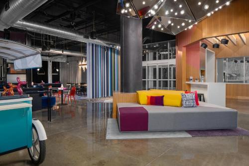 a living room with a couch with colorful pillows at Aloft Houston Shenandoah - The Woodlands in Shenandoah