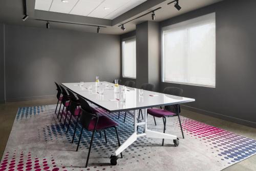 a conference room with a white table and chairs at Aloft Houston Shenandoah - The Woodlands in Shenandoah