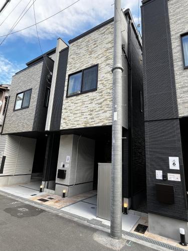 a building with two garage doors and a pole at Casa Stella 5 by Liaison in Osaka