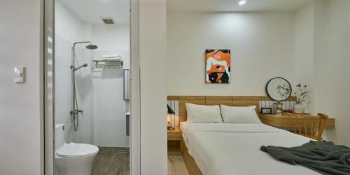 Un dormitorio con una cama, una ducha y un inodoro. en Green Riverside Hotel & Apartment, en Ho Chi Minh