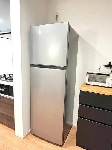 a refrigerator in a kitchen next to a microwave at Casa Stella 5 by Liaison in Osaka