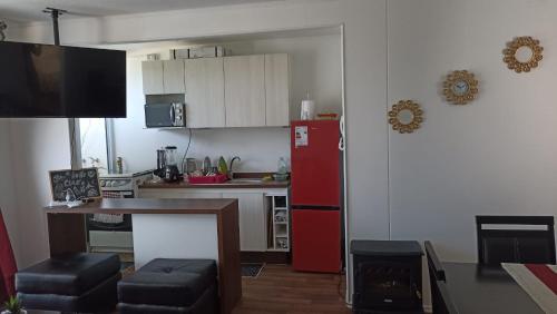 a kitchen with a red refrigerator and a table at Departamento Condominio Parque Pucón in Pucón