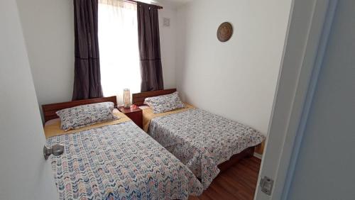a bedroom with two beds and a window at Departamento Condominio Parque Pucón in Pucón