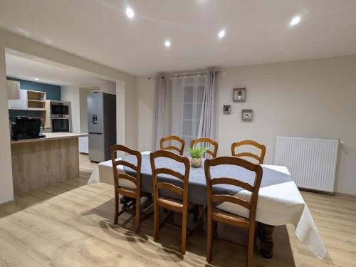 une salle à manger avec une table et des chaises et une cuisine dans l'établissement Gîte cosy avec terrasse, proche Épinal, golf et lac, pour 6 pers, toutes commodités incluses - FR-1-589-430, à Les Forges