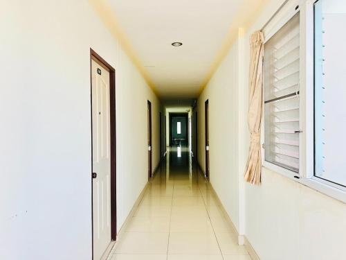 an empty hallway with white walls and a long corridor at Udon Perfect Mansion in Udon Thani