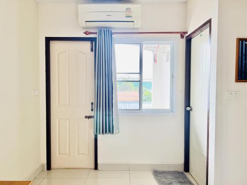 a door with a striped curtain next to a window at Udon Perfect Mansion in Udon Thani