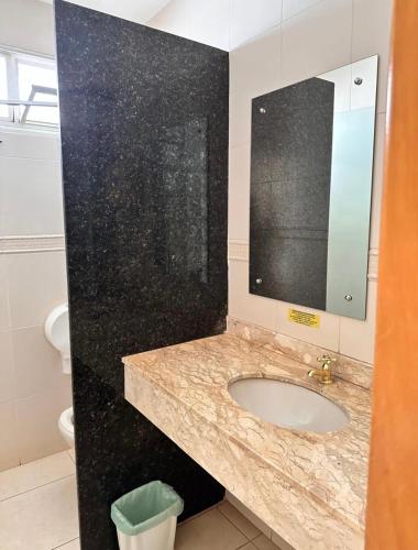 a bathroom with a sink and a mirror at Flat Vintage in Ribeirão Preto