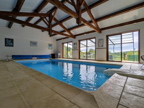 - une grande piscine dans une chambre dotée de plafonds en bois dans l'établissement Ferme de charme avec piscine et tennis privés - FR-1-582-496, à Saint-Romain-Lachalm