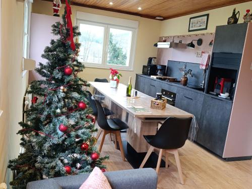 a christmas tree in a kitchen with a table and chairs at Maison spacieuse avec SPA, nature & calme dans les Vosges - FR-1-589-757 in Fraize