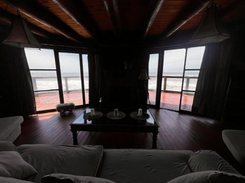 a living room with a couch and a table with windows at La Proa in Aguas Dulces