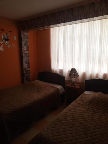 a hotel room with two beds and a window at Hostal Puerto Alegre in Copacabana