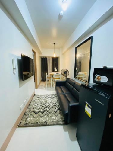 a living room with a black couch and a table at SMDC Shore 3 Residences in Manila