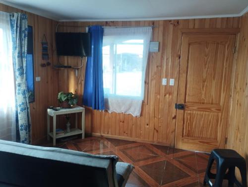 a living room with a window and a door at Cabañas encanto de Chovellen in Pelluhue