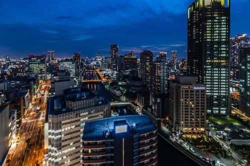 a city skyline at night with many tall buildings at APA Hotel Osaka Higobashi Ekimae in Osaka