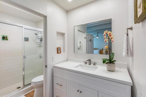 a white bathroom with a sink and a toilet at Puamana 26B in Princeville
