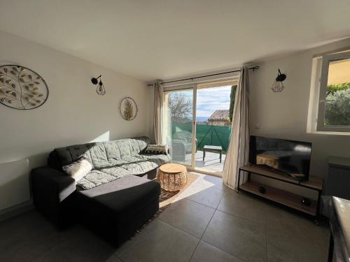 un salon avec un canapé et une grande fenêtre dans l'établissement Maison sur la colline du Barroux, à Le Barroux