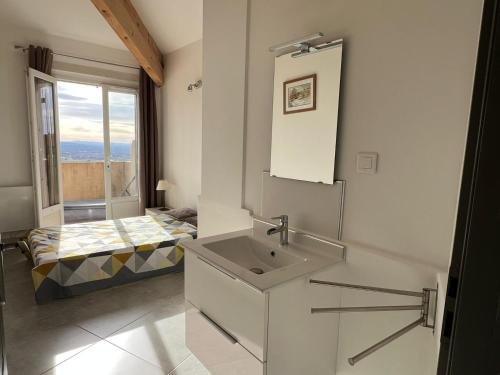 La salle de bains est pourvue d'un lavabo et d'un lit avec une fenêtre. dans l'établissement Maison sur la colline du Barroux, à Le Barroux