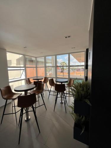 un gruppo di tavoli e sedie in una stanza con finestre di Studio Westfit maior espaço a Mossoró