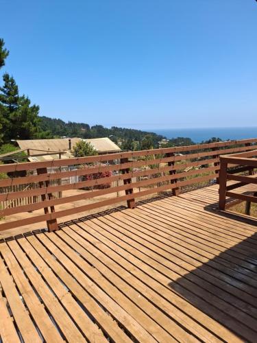 a wooden deck with a fence and a view of the ocean at Cabaña Mi Paraíso in Valparaíso