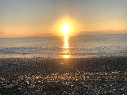 a sunset over the ocean on a rocky beach at 金讚溫泉飯店 in Taimali