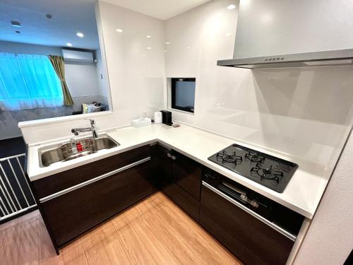 a small kitchen with a sink and a stove at Casa Stella 8 by Liaison カーサステラ8 byリエゾン in Osaka