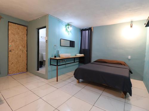a bedroom with a bed and a bathroom with a sink at Casa Corazon Centro in Oaxaca City