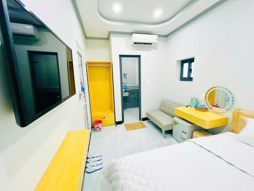 a bedroom with a bed and a tv on a wall at Sand Sea Hotel in Phan Thiet