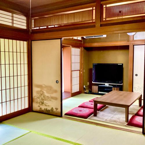 a living room with a table and a tv at #熱海古民家 #来宮神社 バーベキュー温泉 in Atami