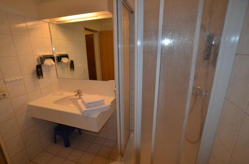 uma casa de banho com um lavatório e um chuveiro em Ferienwohnung 2 im Haus Hühnergott Sellin em Ostseebad Sellin