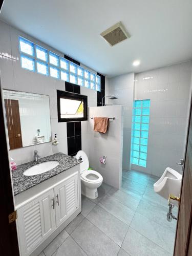 a bathroom with a sink and a toilet and a window at villa kitty in Ban Thung Satong