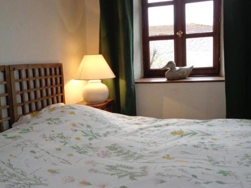 a bedroom with a bed with a bird sitting on a window at Découvrez ce gîte champêtre avec spa, sauna, piscine et jardin privatif à Essertines-en-Donzy - FR-1-496-200 in Essertines-en-Donzy