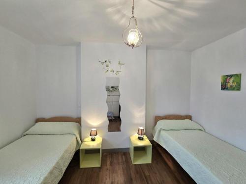 - 2 lits dans une chambre blanche avec 2 tables dans l'établissement Maison rénovée avec grand jardin, proche des Eyzies et sites touristiques du Périgord Noir - FR-1-616-37, à Campagne