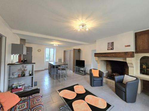 un salon avec un canapé et une cheminée dans l'établissement Maison rénovée avec grand jardin, proche des Eyzies et sites touristiques du Périgord Noir - FR-1-616-37, à Campagne