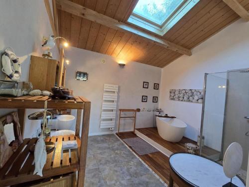bagno con 2 lavandini e vasca di Maison en bois avec piscine privée chauffée, terrasse et jardin - Ideal famille et nature - FR-1-616-96 a Montagrier
