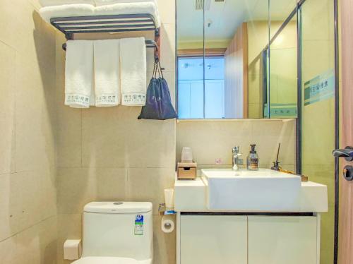 a bathroom with a sink and a toilet and a mirror at 浮生慢遇酒店 in Dali Airport