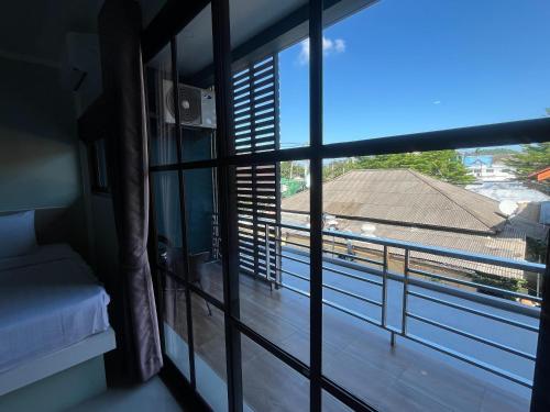 a room with a window with a view of a roof at J & Ariya Hotel Near Samui Airport and Koh Phangan Pier in Bophut 