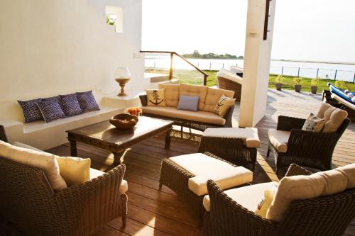 a living room with couches and chairs on a deck at Villa Santé by The Serendipity Collection in Kalpitiya