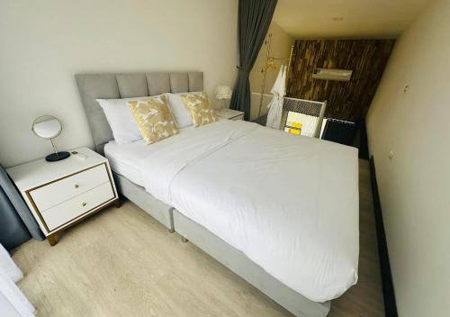 a bedroom with a white bed and a night stand at Pai Cheese cottage in Pai