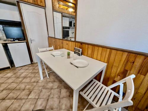 - une table et des chaises blanches dans la chambre dans l'établissement Studio Montagne - Calme, Tout Equipé proche Centre, à Grenoble