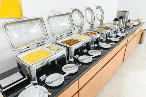 a buffet line with many different dishes of food at Ezza Experience - Beach Flat in Recife